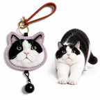 Personalized wool felt tuxedo cat portrait charm and keychain shown next to the real cat comparison on a white background.