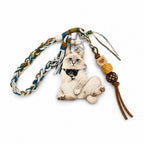 A collection of custom 3D pet relief keychains and bag charms with personalized hand-painted animal portraits on a textured surface.