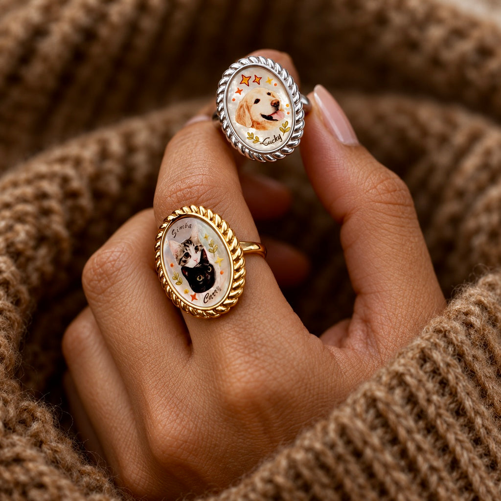 Gold two-cat portrait ring and silver dog portrait ring worn together with knit sleeves