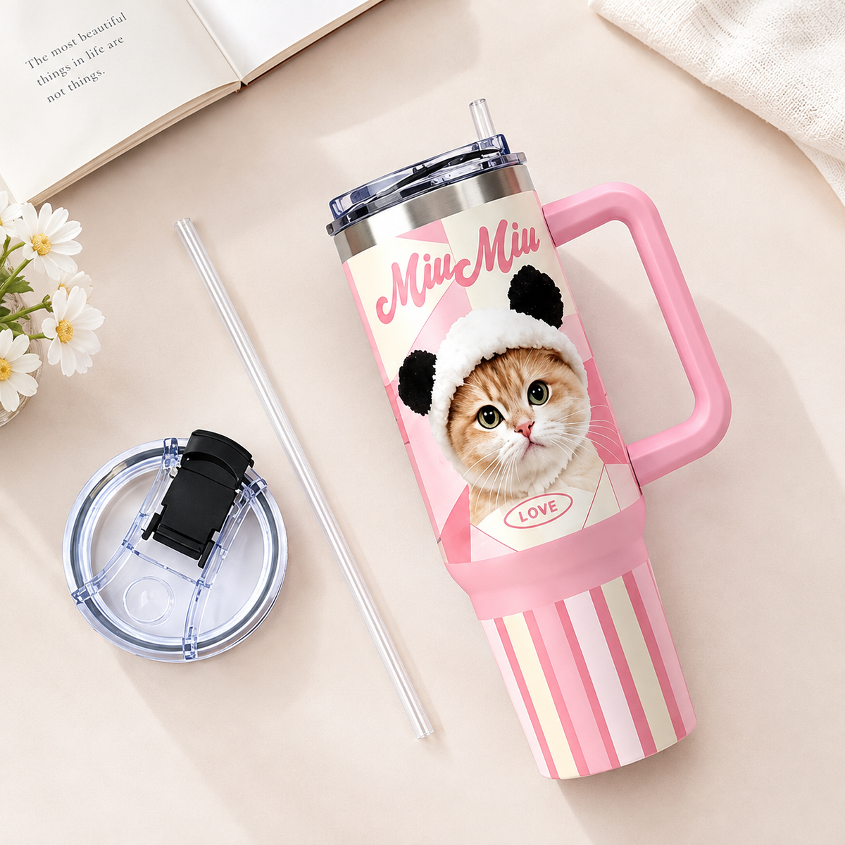 Flat lay of a pink custom cat photo tumbler with its clear lid and straw placed beside it