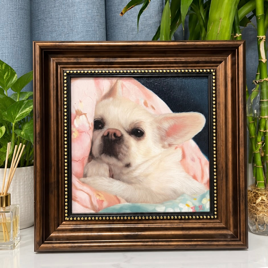 Custom hand-painted oil painting portrait of a white Chihuahua resting in a dark wooden frame, displayed on a table next to bamboo and reed diffusers.