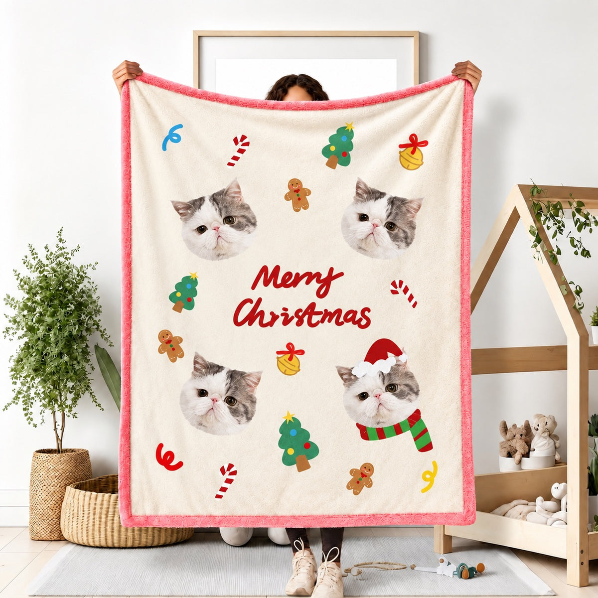 Person holding a pink custom cat photo flannel blanket with Merry Christmas text and holiday ornaments