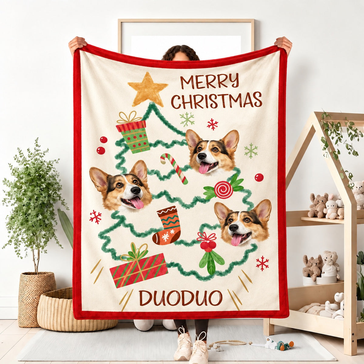 Person holding a custom red Christmas fleece blanket featuring Corgi dog portraits, a Christmas tree, and the personalized name Duoduo.