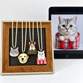 Four custom dog and cat portrait necklace examples displayed beside a cat reference image