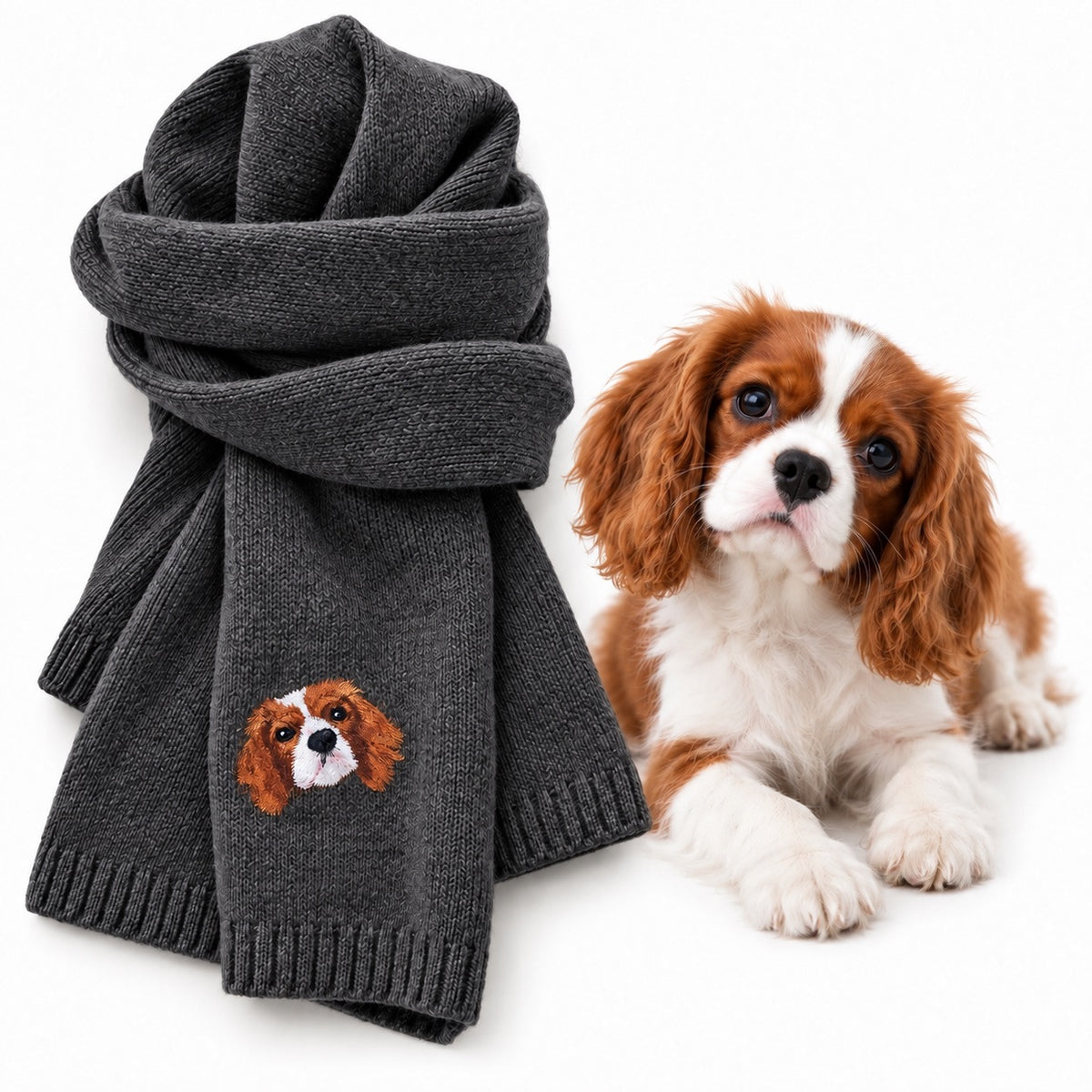 Brown knit scarf embroidered with a Cavalier dog portrait displayed beside a gray-and-white dog