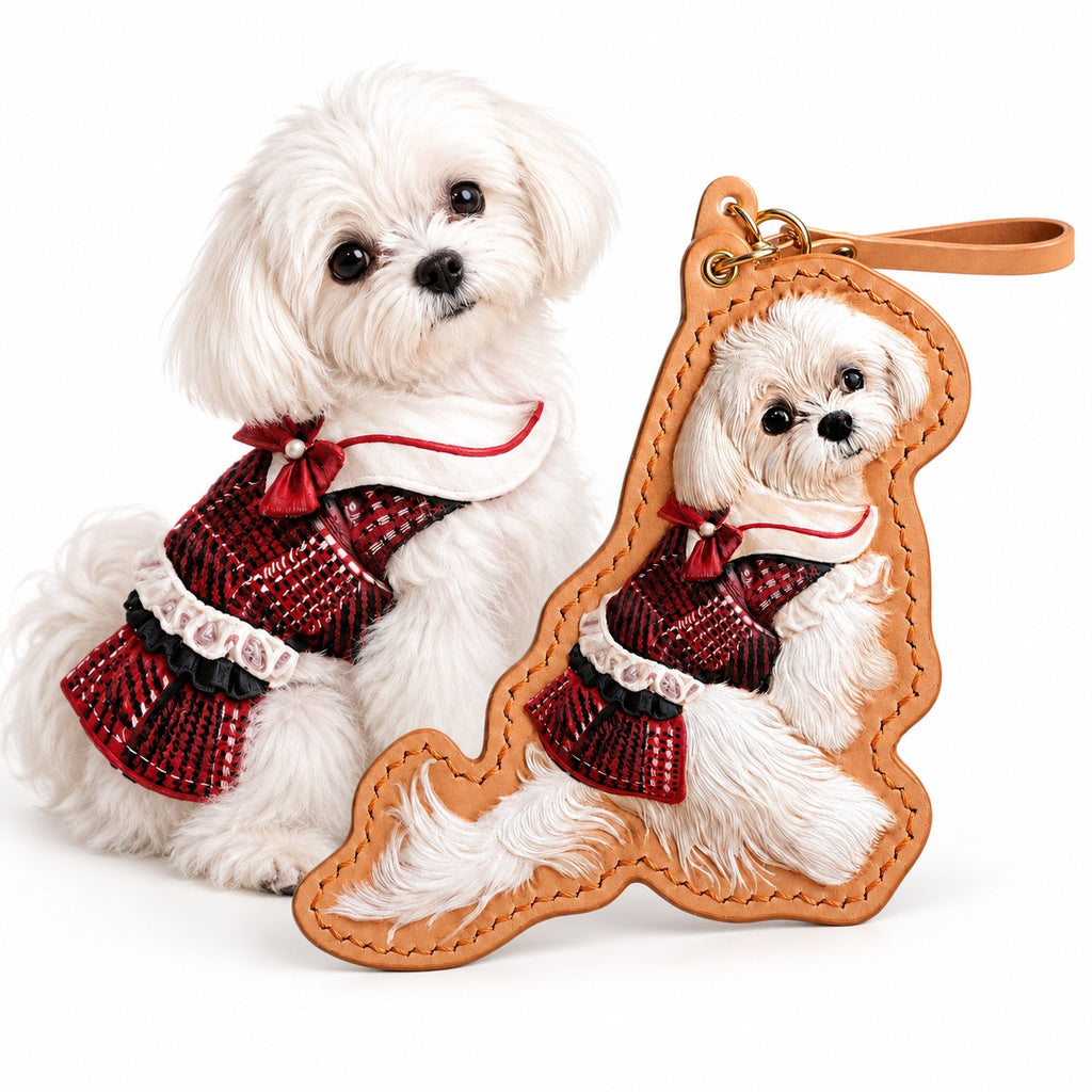 Custom full-body 3D hand-carved leather pet portrait keychain of a small white dog in a red plaid dress, displayed next to the real dog in a matching outfit.