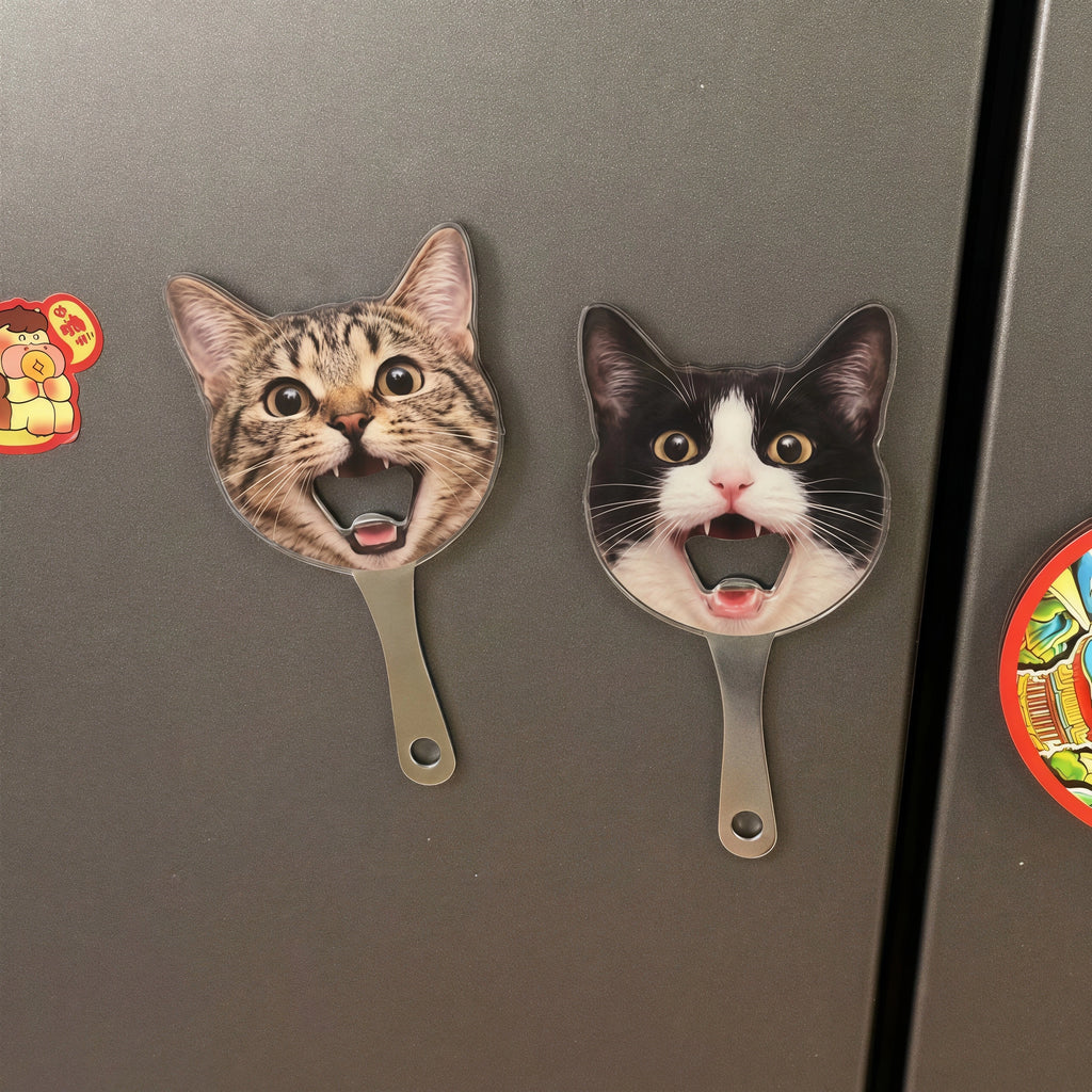 Two personalized pet photo magnetic bottle openers shaped like cat faces stuck securely onto a stainless steel refrigerator door.