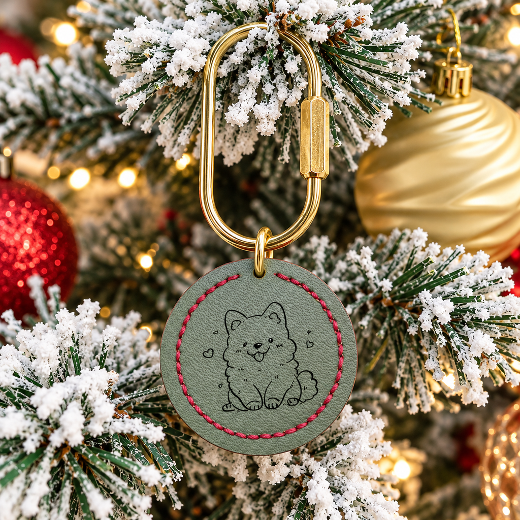 Personalized cowhide pet portrait charm hanging from a decorated Christmas tree