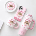 Custom pet portrait gift set in pink checkered pattern featuring personalized cat photo mug, tumbler, phone case, and pin badge next to a white cat.