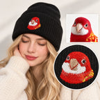 Woman wearing a black knit beanie embroidered from a red parrot photo, with the reference image and stitch detail