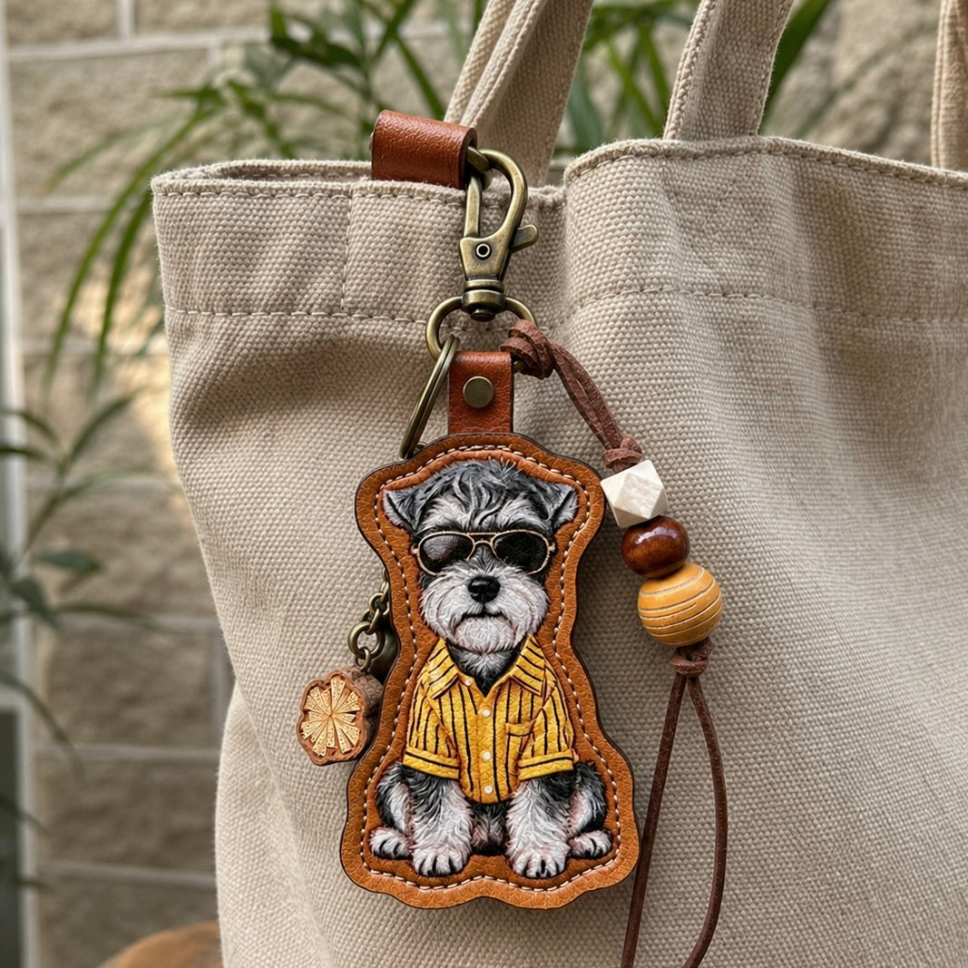 A custom illustrated Schnauzer dog portrait leather bag charm wearing sunglasses and a yellow striped shirt, styled as a personalized pet photo keychain with decorative beads.