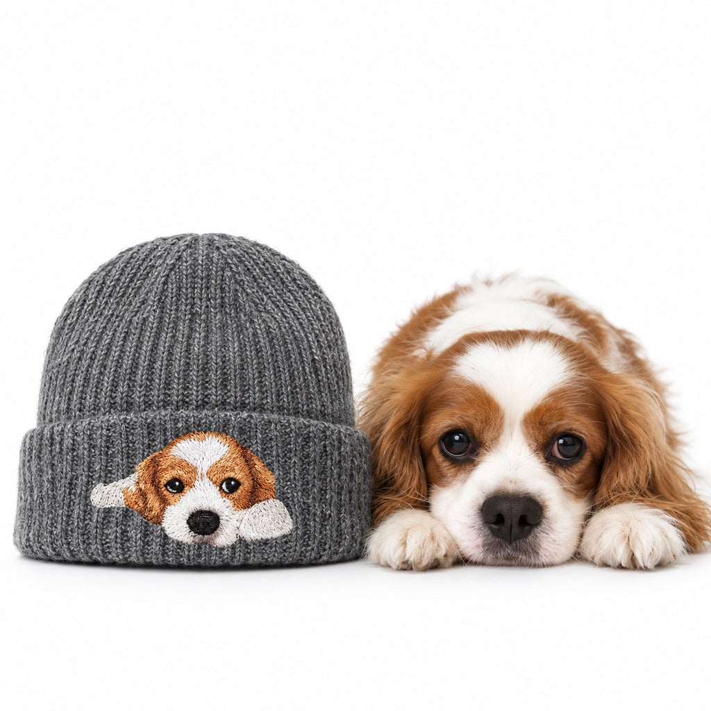 Gray knit beanie embroidered with a brown-and-white spaniel portrait beside the dog on a white background