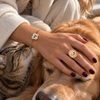 Gold dog portrait ring and cat portrait bracelet worn while resting a hand on two pets