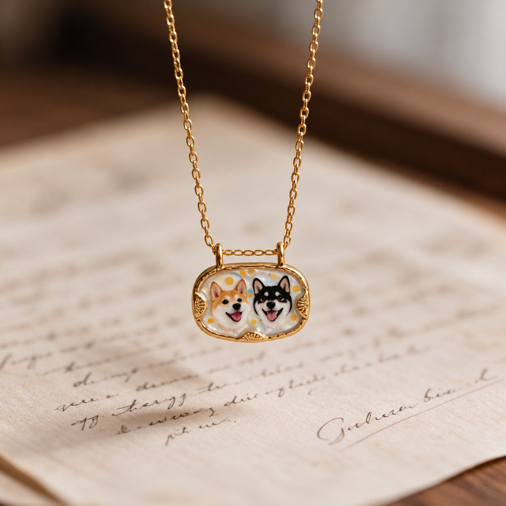Gold-tone double pet portrait necklace displayed over a handwritten letter