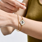 Close-up view of a personalized pet photo clover charm bracelet with a sliding chain worn on the wrist.