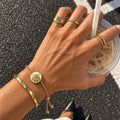 Gold single-chain pet hair memorial bracelet with an engraved cat portrait worn on a wrist