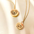Two gold dog hair memorial necklaces engraved with personalized dog portraits and names