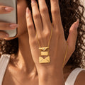 Open gold envelope necklace held in a hand with the customizable inner card extended