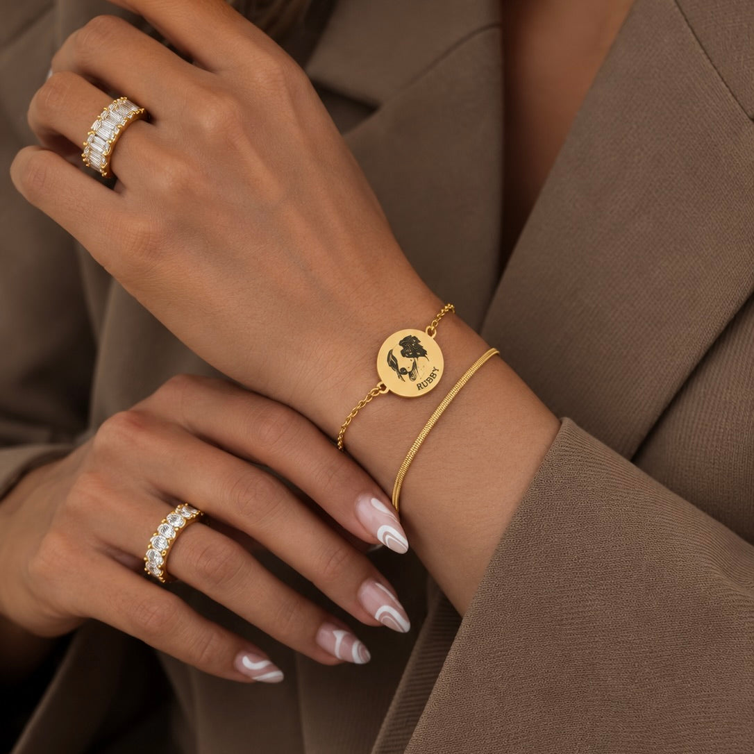 Gold layered pet memorial bracelet with a custom dog portrait and name worn with a brown suit