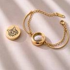 Open gold double-chain pet bracelet showing the small interior compartment with a fur clipping