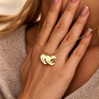 Gold-tone double paw print heart name necklace worn by a woman