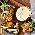 Gold-tone compact mirror engraved with a floral design and name beside an open mirror