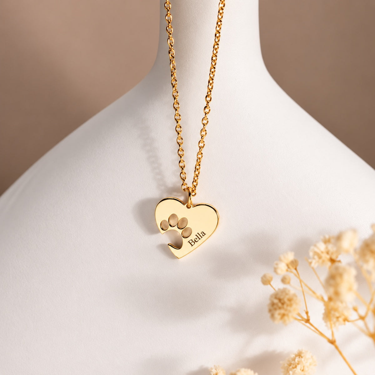 Gold-tone paw print heart necklace personalized with the engraved name Bella