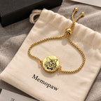 Gold single-chain pet portrait keepsake bracelet displayed on a neutral fabric pouch
