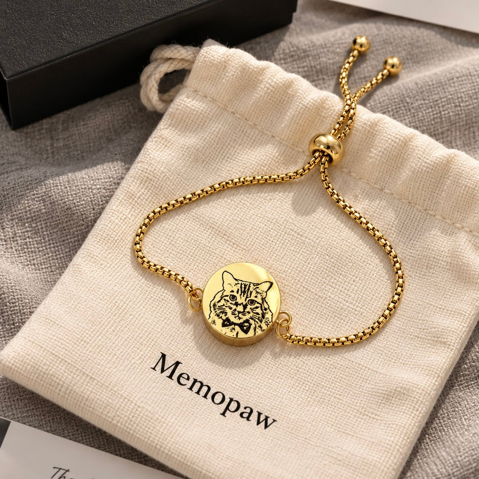 Gold single-chain pet portrait keepsake bracelet displayed on a neutral fabric pouch