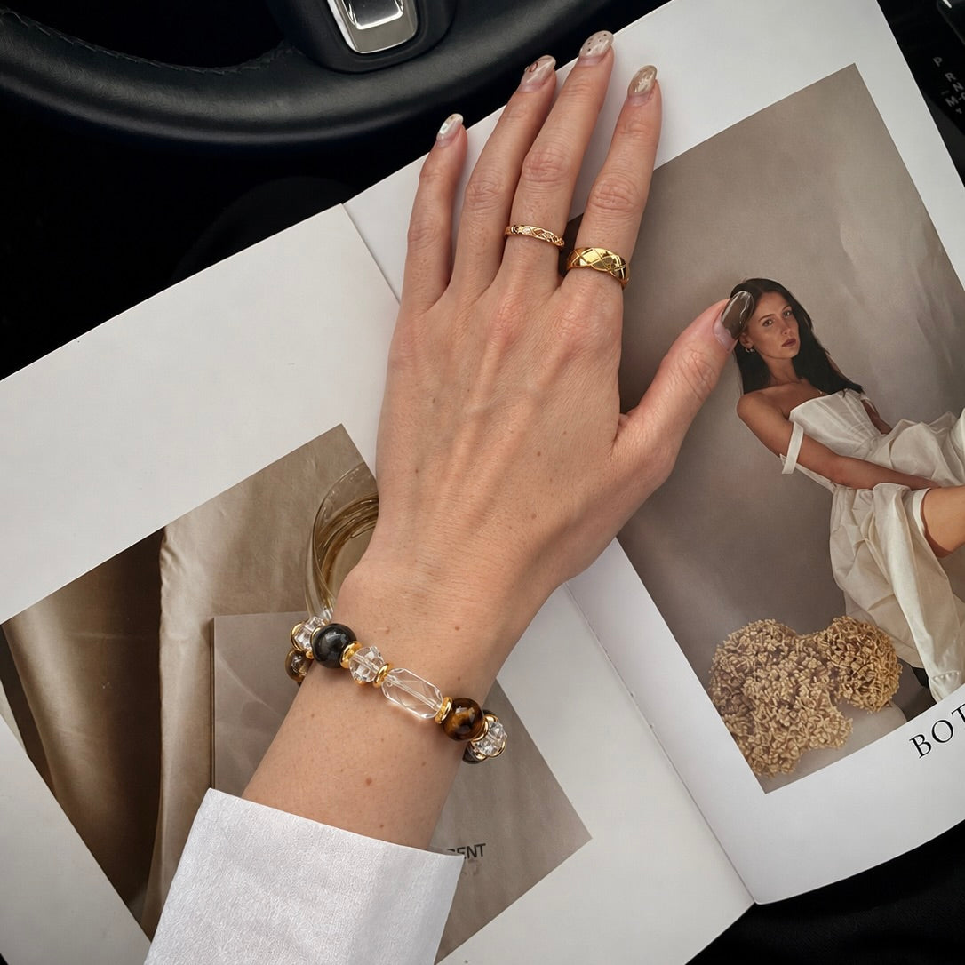 Hand wearing a beaded crystal bracelet and gold rings next to a lookbook editorial featuring matching pet and owner jewelry
