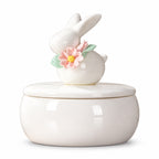 Ivory ceramic rabbit memorial urn with a removable lid decorated with a rabbit figure, pink flowers and green leaves |