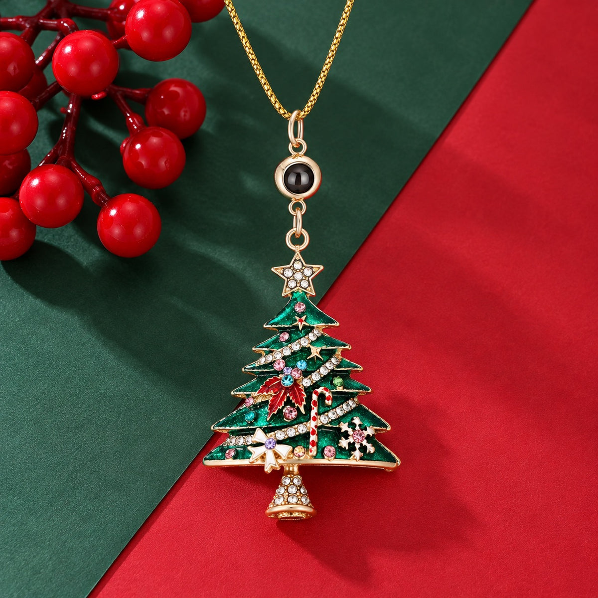 Gold-tone photo projection necklace with a green jeweled Christmas tree pendant on a red and green background