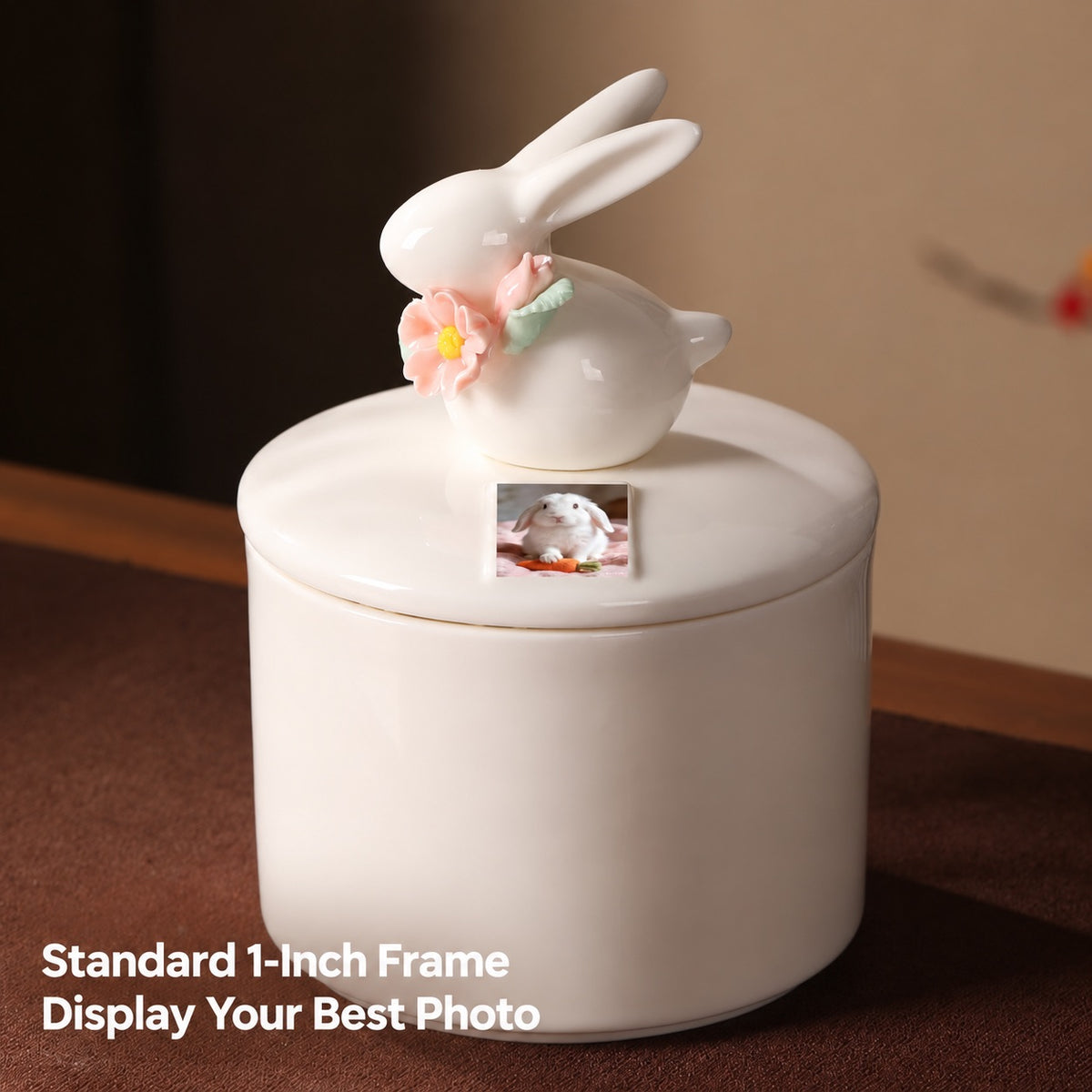 Large ivory ceramic rabbit memorial urn with pink flowers and a small printed pet rabbit photo in the designated one-inch display area