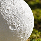 Close-up of the cratered moon texture and center seam on the white pet memorial urn