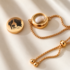 Open gold pet portrait bracelet showing the small interior compartment with a clipping of fur