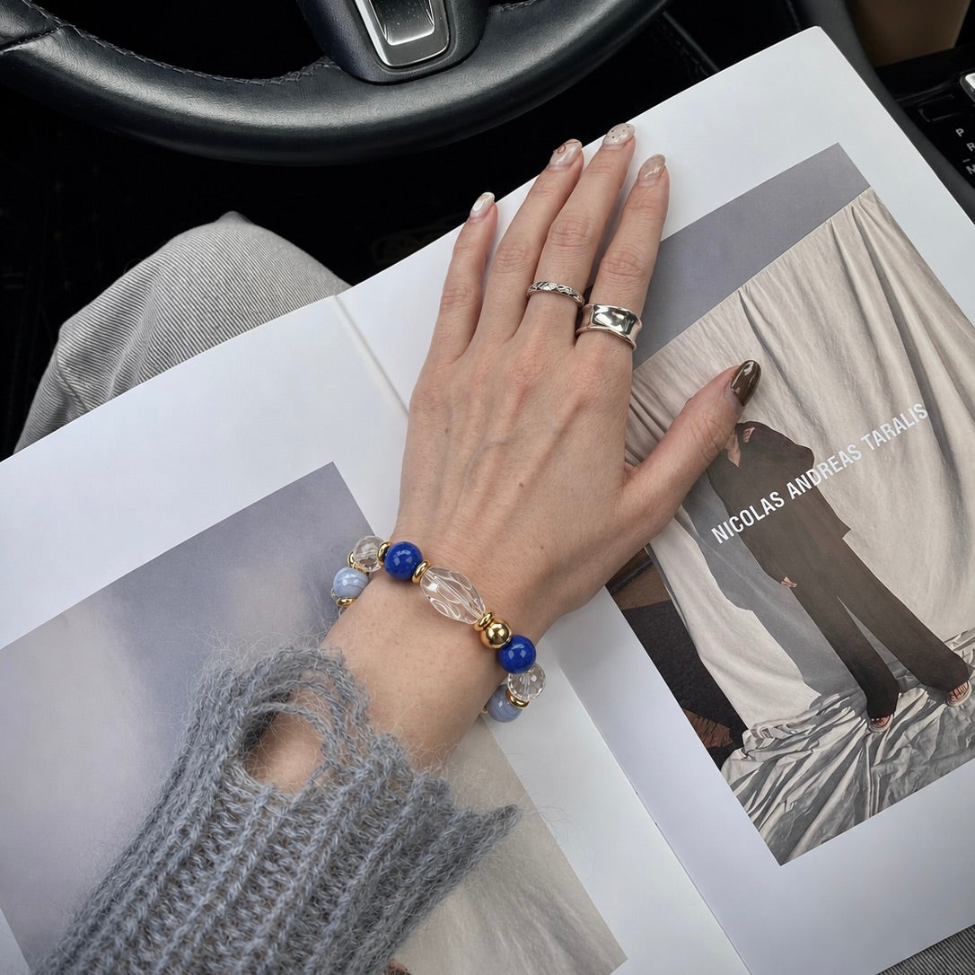 Hand wearing a beaded crystal bracelet and gold rings showcasing matching pet and owner jewelry collection