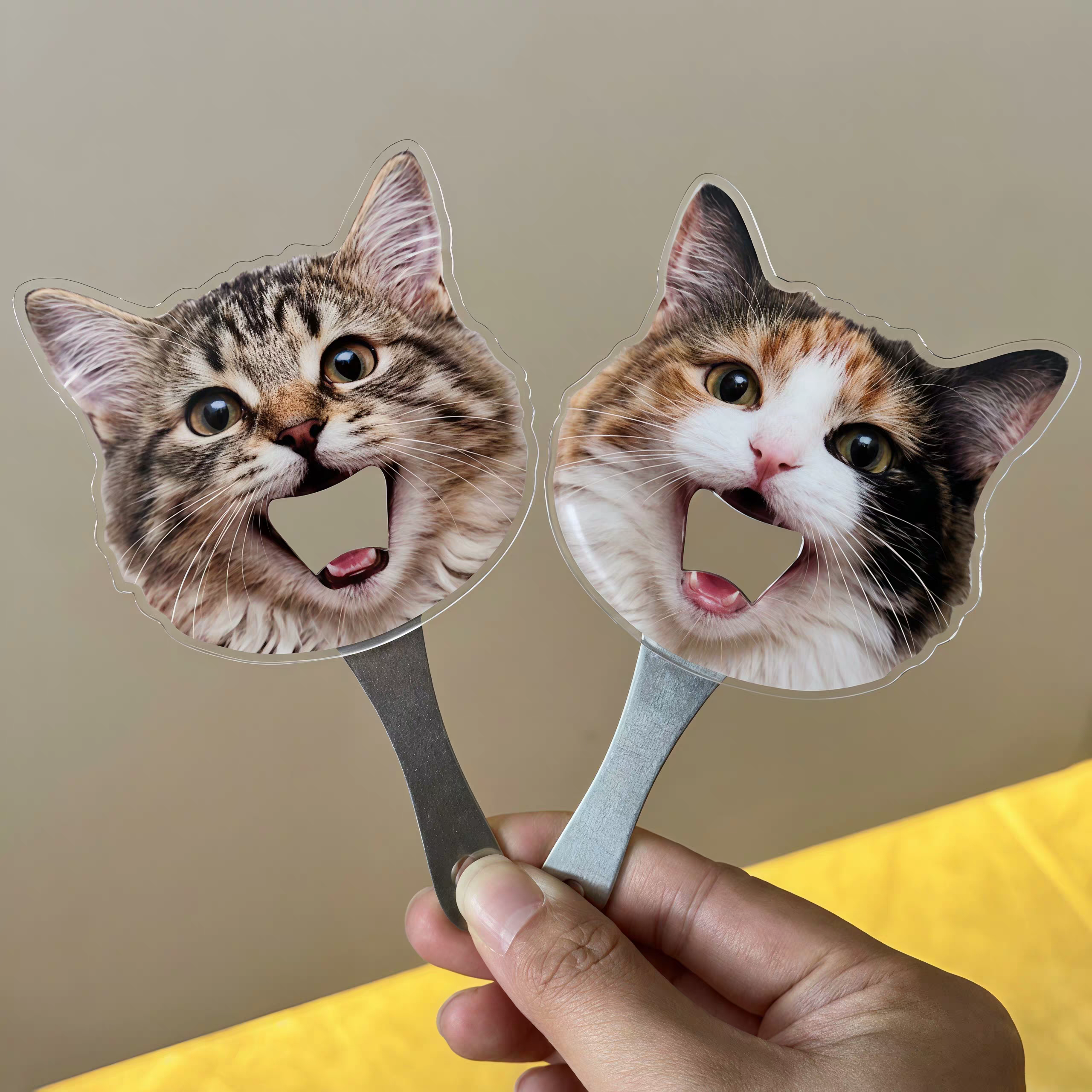 Two custom-shaped magnetic bottle openers featuring personalized prints of funny open-mouth cat faces.