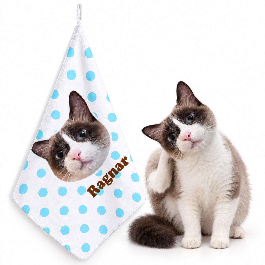 Blue polka-dot personalized cat photo hanging hand towel with the name Ragnar, displayed next to the cat.