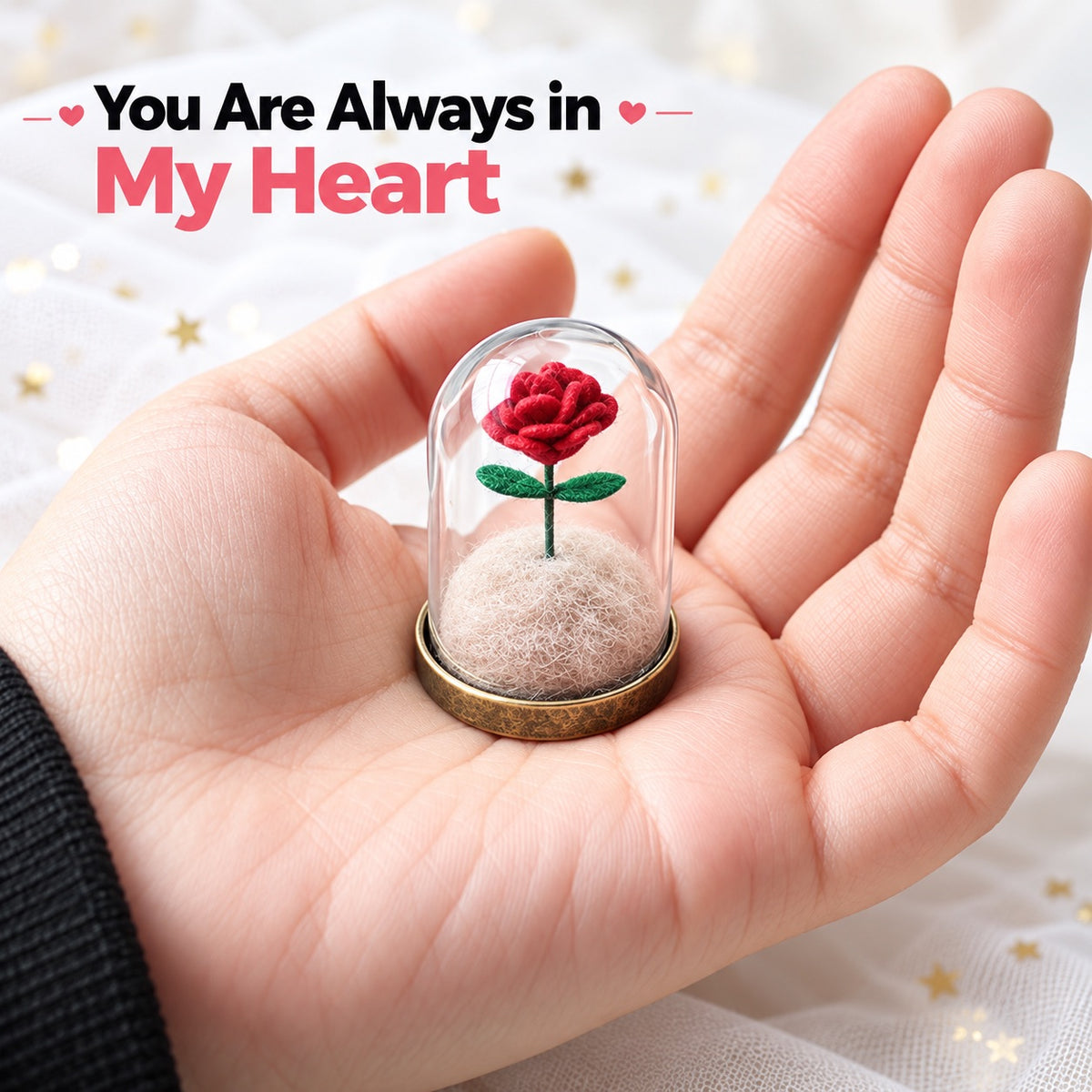 Miniature red fabric rose and pet fur keepsake under a clear dome held in one hand