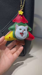 Close-up video of a genuine leather carved Christmas tree keychain
featuring a hand-painted, expressive white cat. Demonstrating how this
unique handmade leather accessory styles a handbag for the festive
season. Ideal for those seeking personalized pet leather art or cute
stocking stuffers.