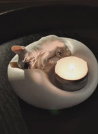 Video preview of a matte white plaster sleeping French Bulldog candle holder and jewelry trinket tray with a lit tealight candle, cozy pet-themed home decor by Memopaw.Small French Bulldog tray for rings earrings and tealights