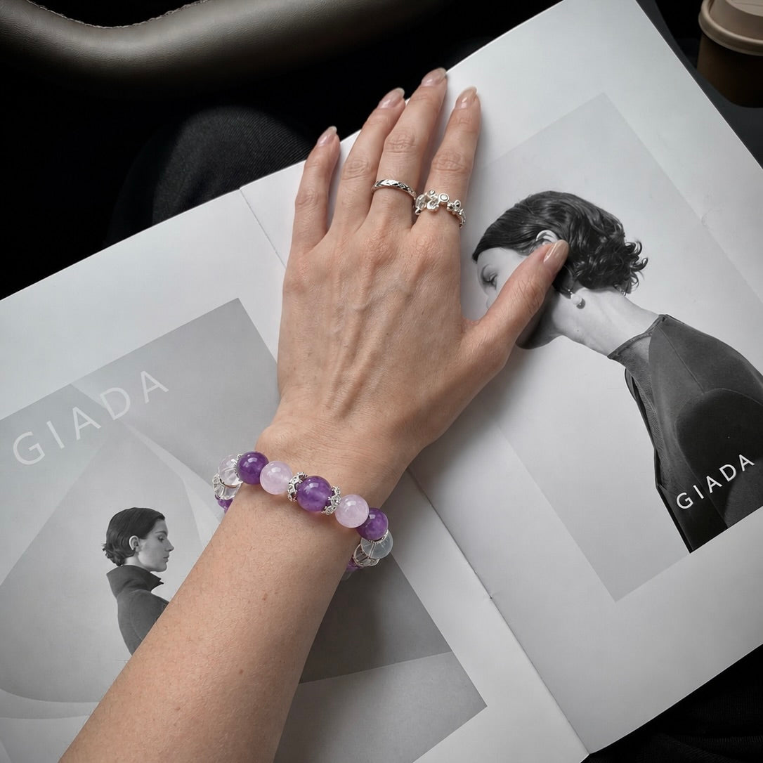 Hand wearing a purple crystal bead bracelet next to a lookbook page showcasing matching pet and owner jewelry