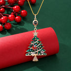 Close-up of a green jeweled Christmas tree projection pendant with gold-tone chain and round photo lens 