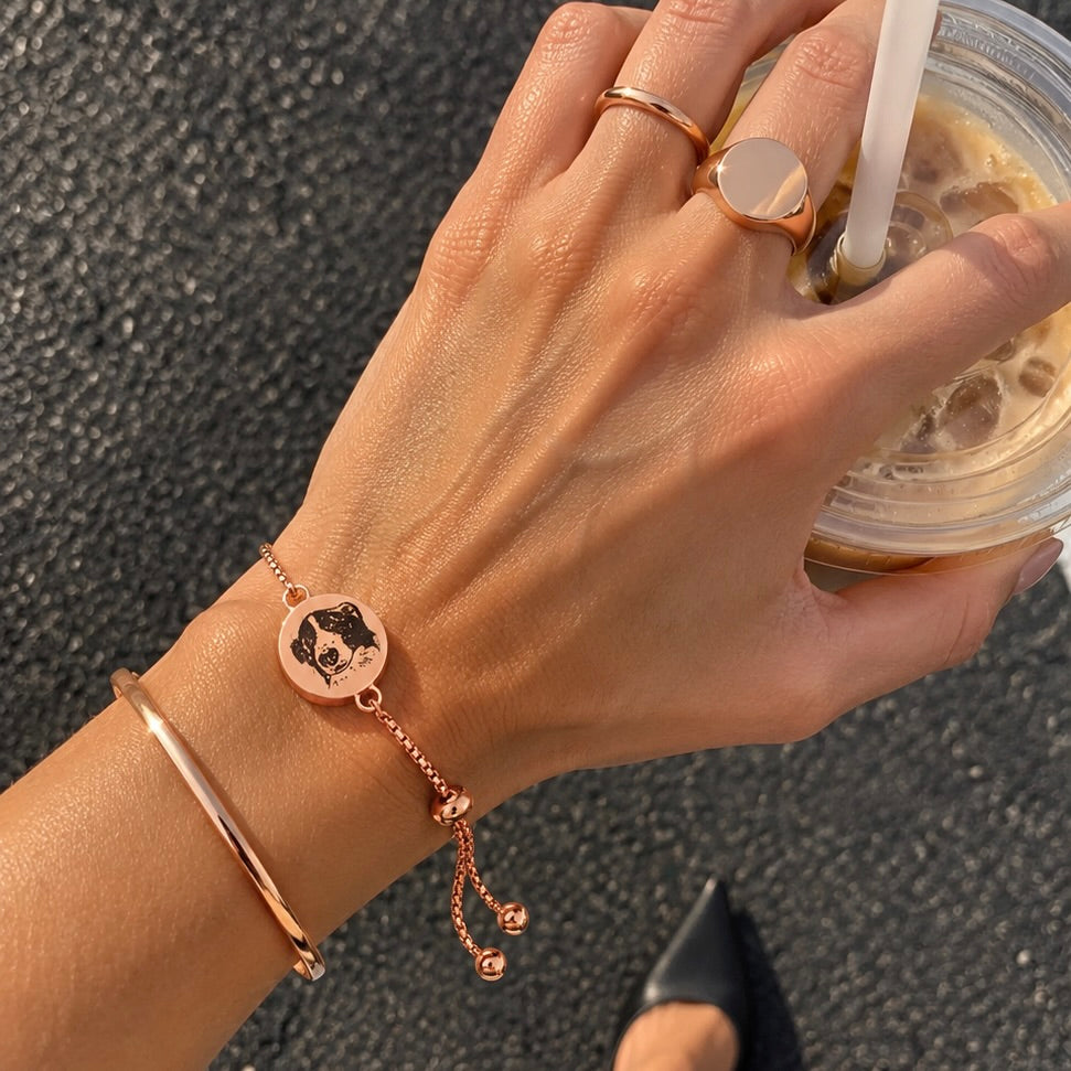 Rose gold single-chain bracelet with an engraved dog portrait worn on a wrist