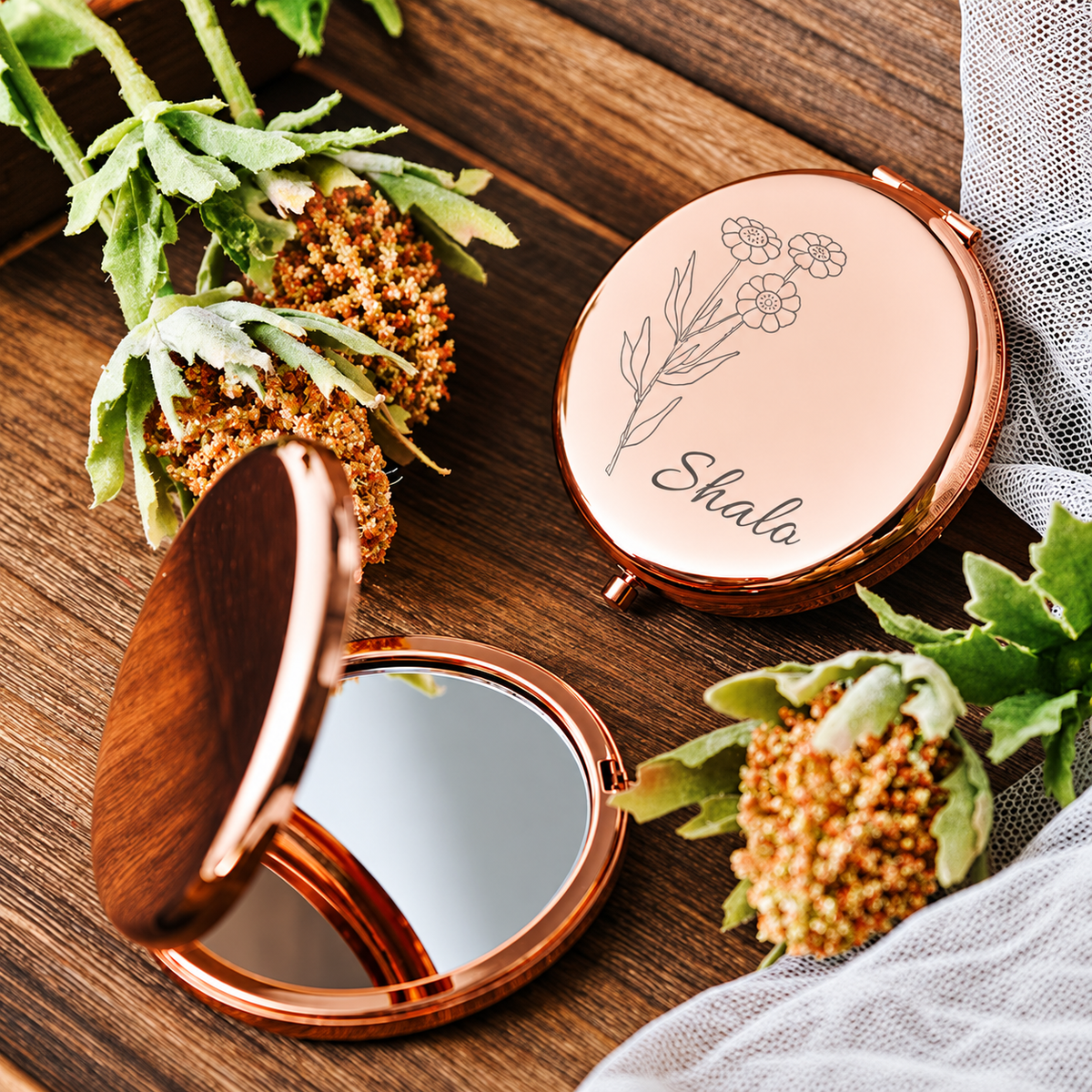Rose gold-tone compact mirror engraved with a floral design and name beside an open mirror