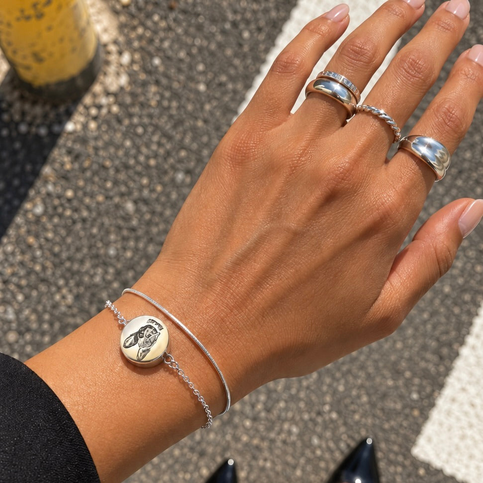 Silver double-chain pet portrait bracelet with an engraved dog image worn on a wrist