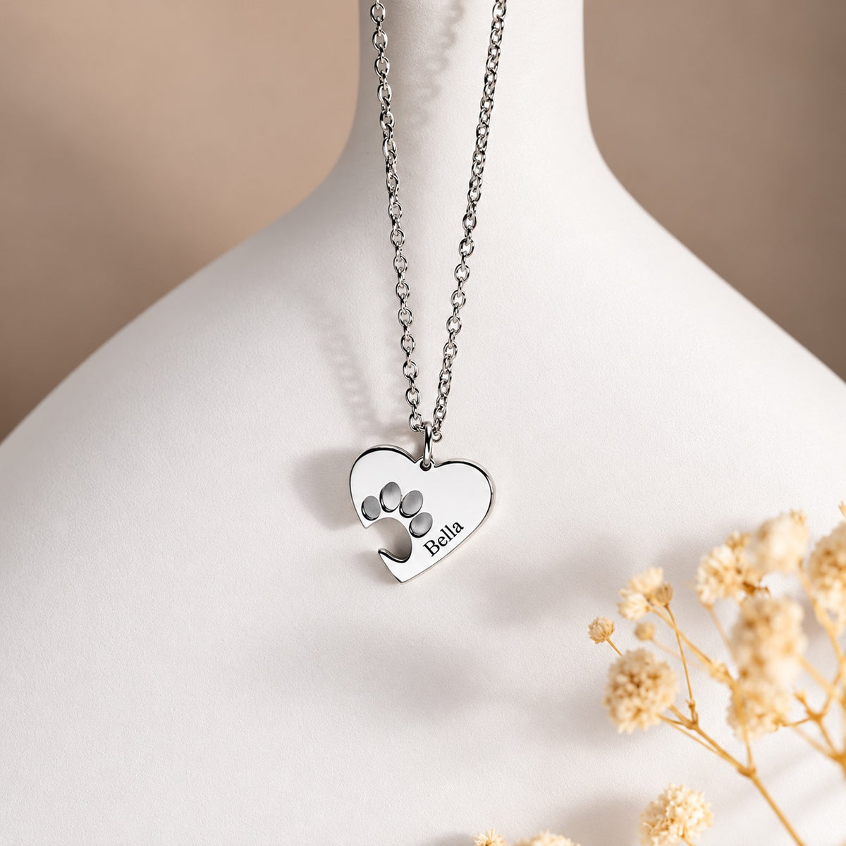 Silver-tone paw print heart necklace personalized with the engraved name Bella