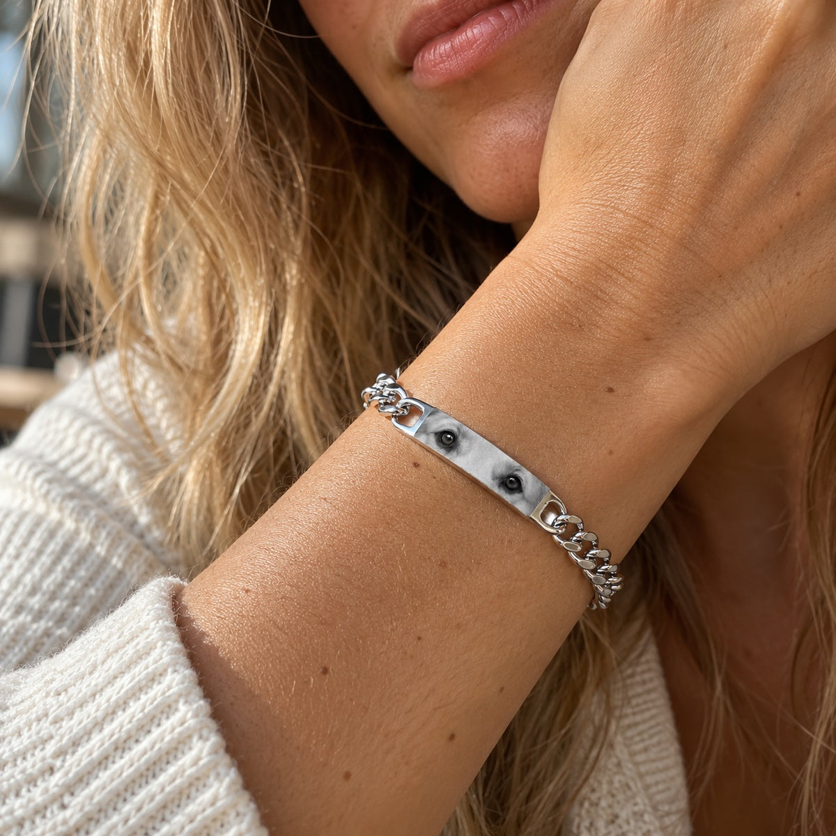Woman wearing a silver-tone bracelet personalized with an engraved portrait of her pet’s eyes