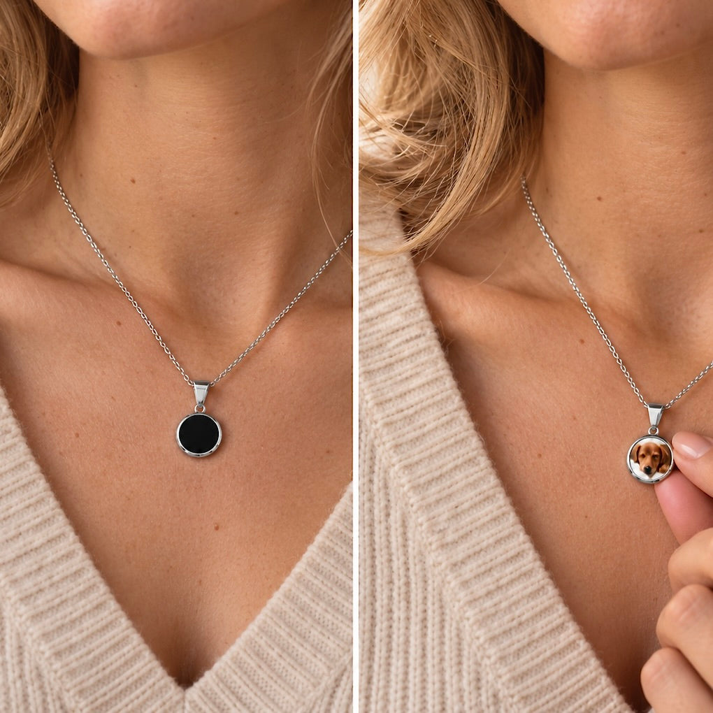 Silver temperature-sensitive necklace changing from black to a custom dog photo under a fingertip