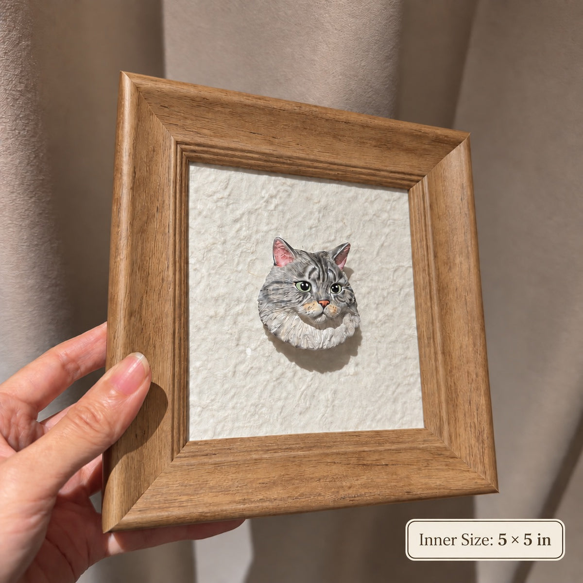 Gray tabby cat head portrait in a warm brown frame, held in sunlight and labeled 5 by 5 inches inner size